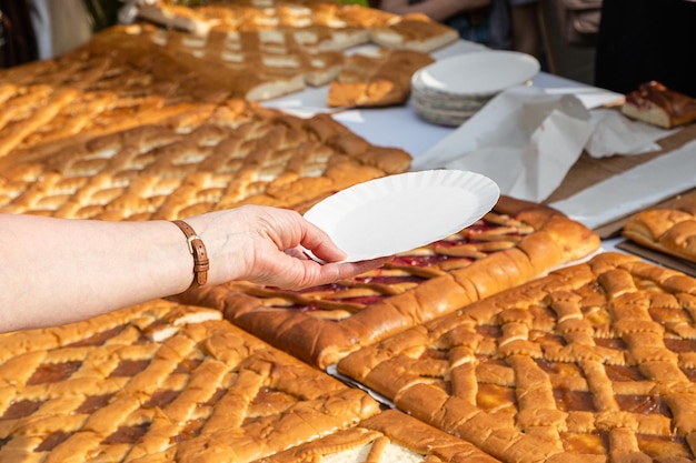 Hand with empty paper plate waits for pie