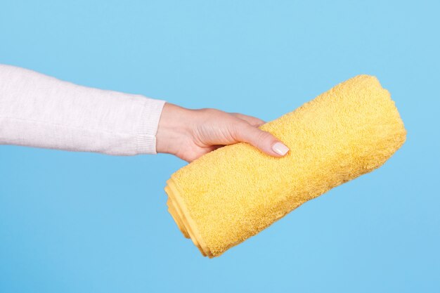 Hand with folded yellow towel isolated