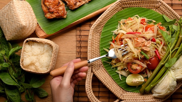 사진 찹쌀과 태국 스타일 구운 닭고기와 함께 somtum 또는 파파야 샐러드를 먹는 포크로 손