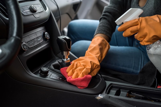 Hand with glove  using  wet wipe and antibacterial spray cleaning  car interior