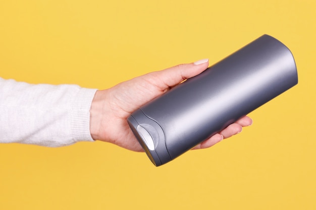 Hand with gray shampoo bottle isolated