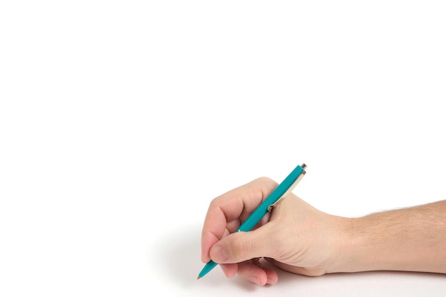 Foto mano con penna a sfera verde durante la scrittura su sfondo bianco