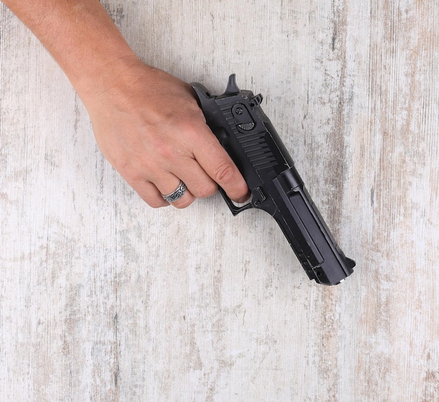 hand with a gun on the table