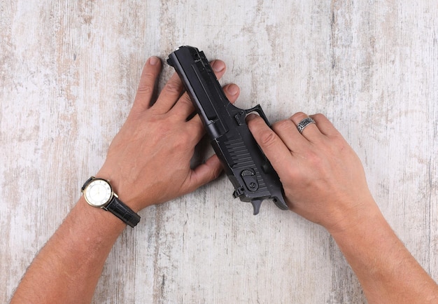 hand with a gun on the table