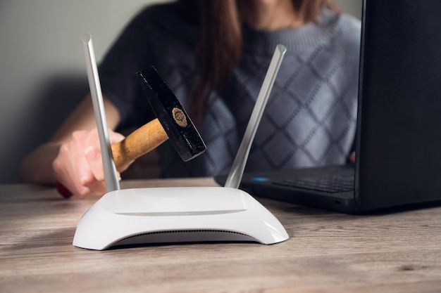 A hand with a hammer and internet modem router