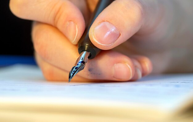 Mano con penna a inchiostro concetto di calligrafia