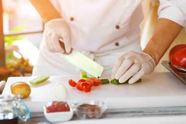 Hand with knife cuts asparagus.