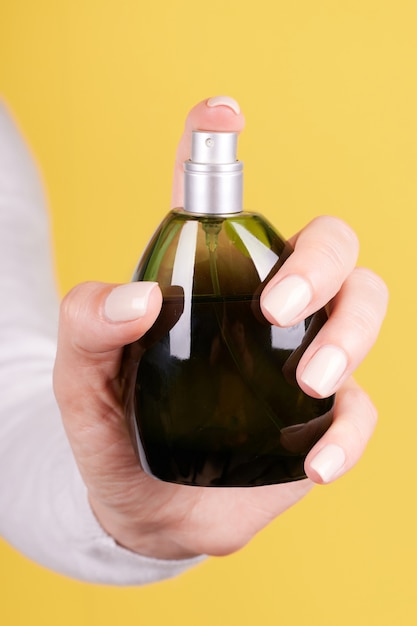 Hand with luxury perfume bottle isolated