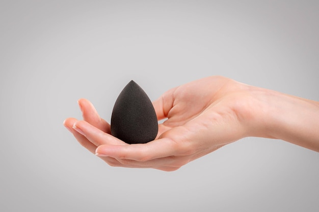 Hand with makeup sponges on white background