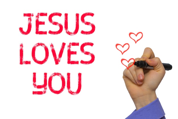 Hand with marker writing the word Jesus Loves You