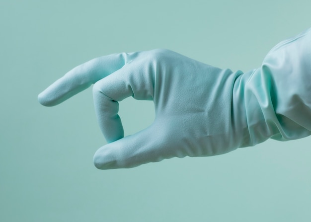 hand with medical glove on green background