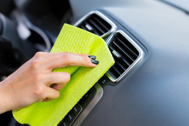 Hand with microfiber cloth cleaning car