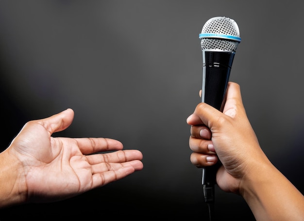 Photo hand with microphone on gray background close up ai generated