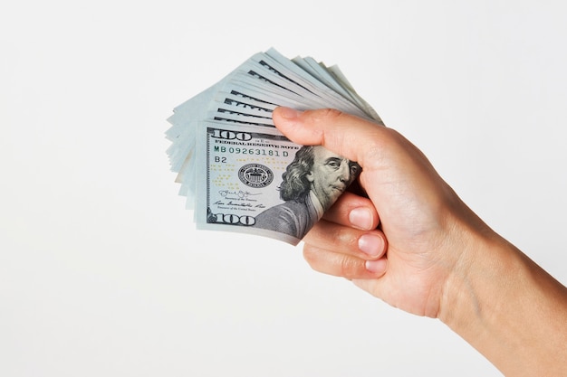 Hand with money isolated on white background with copy space. Woman hand giving dollar money, close-up