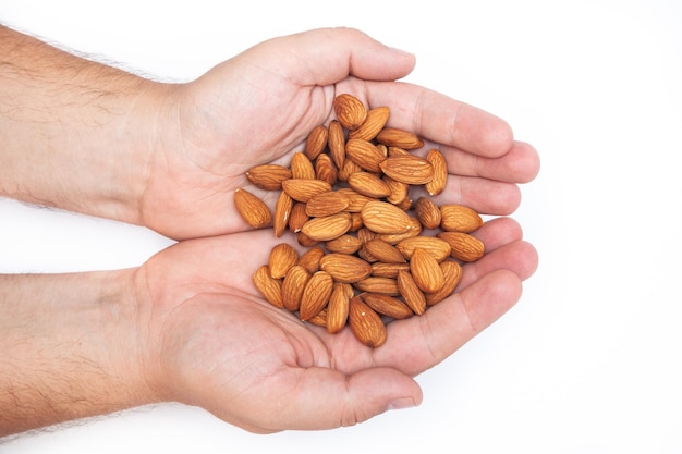 Hand with natural big raw peeled almonds nuts