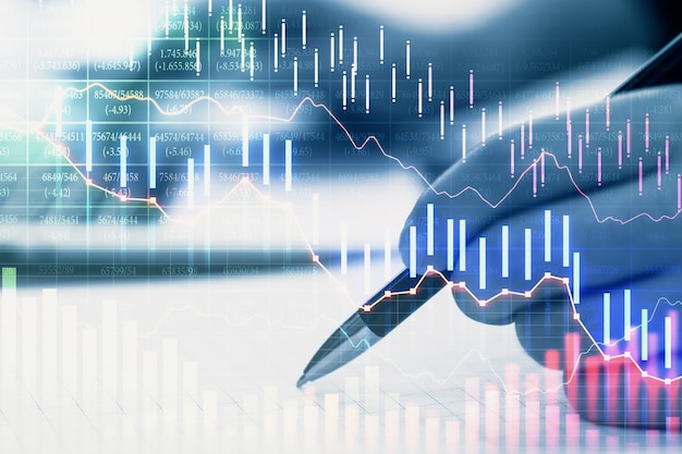 Hand with pen and falling stock chart interface