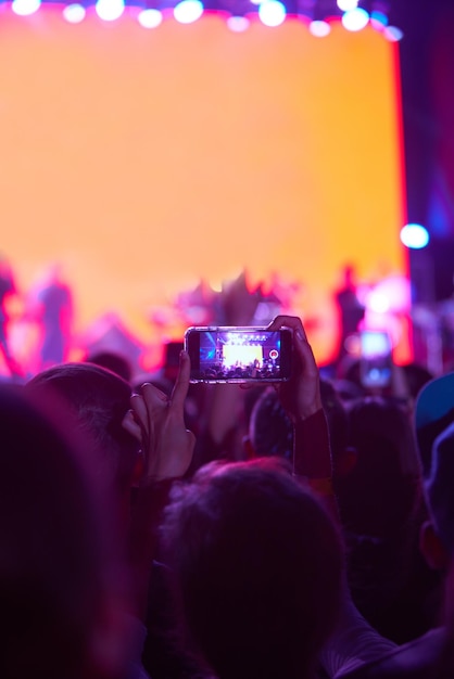 Рука с телефонными записями фестиваль живой музыки Люди фотографируют с телефоном во время концерта