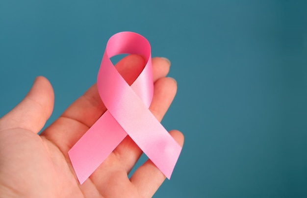 Mano con nastro rosa per la consapevolezza del cancro al seno