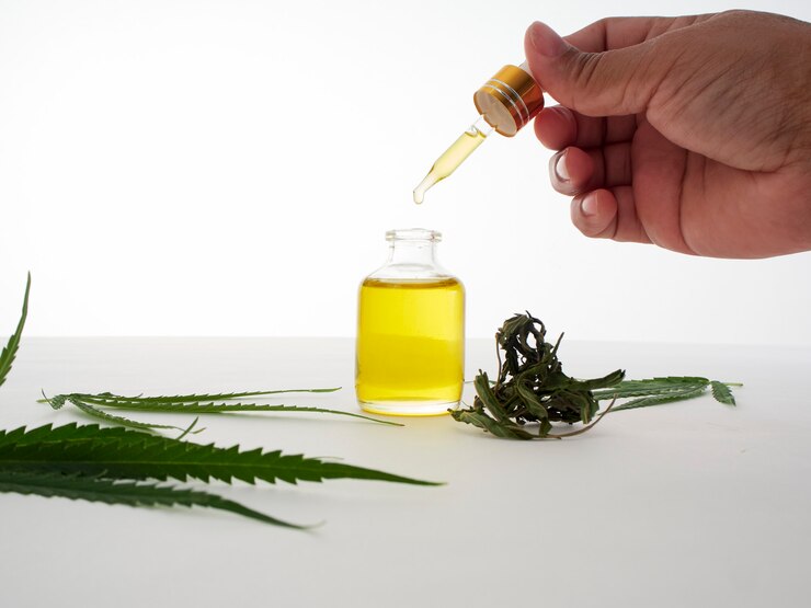 ピペットと大麻抽出油で手。