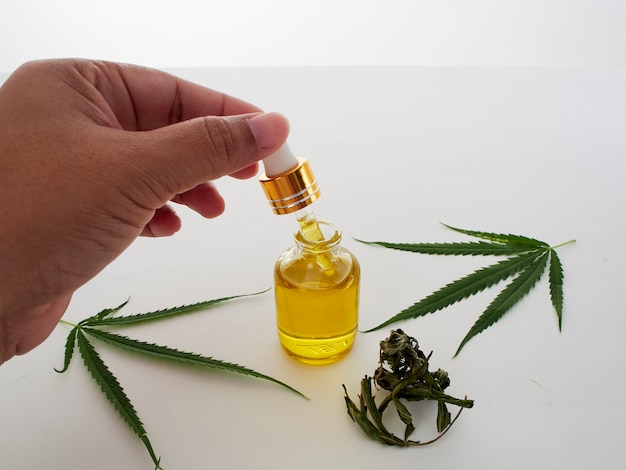 Mano con pipette e olio di estratto di cannabis.