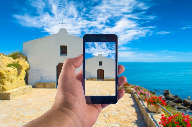 Mano con lo smartphone per scattare foto in una giornata di sole