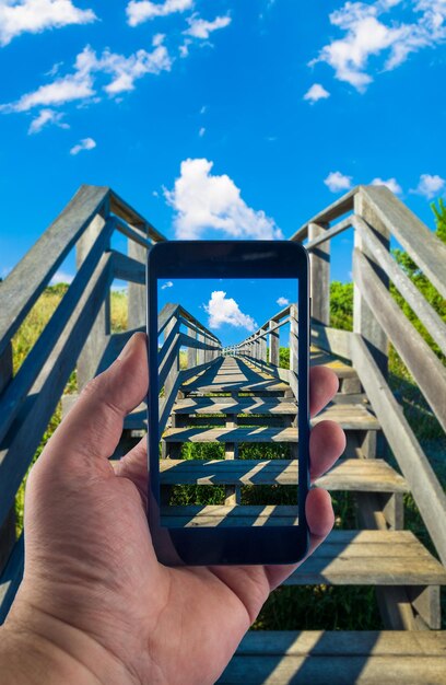 Mano con lo smartphone per scattare foto in una giornata di sole