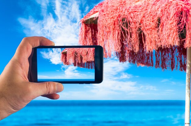 Foto mano con lo smartphone per scattare foto in una giornata di sole