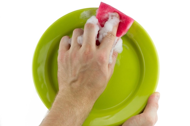 Hand with a sponge washes a plate