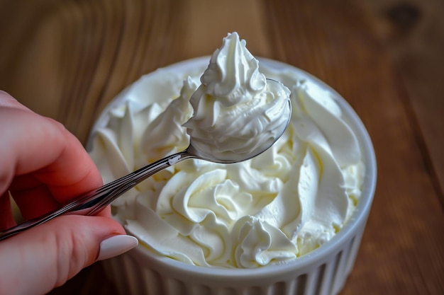 Photo hand with spoon taking a dollop of whipped cream