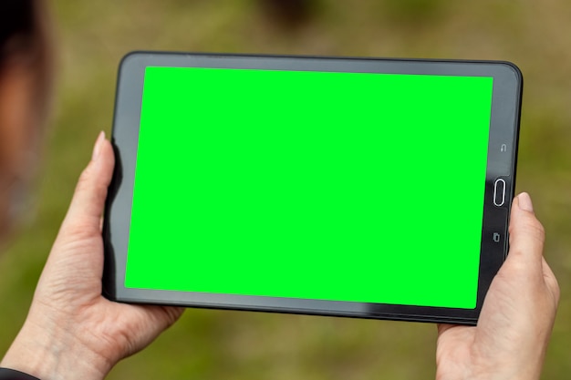 Photo hand with a tablet lying on it, map-case close-up, green screen mockup, layout.