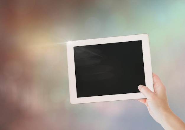 Hand with tablet with sparkling light bokeh background