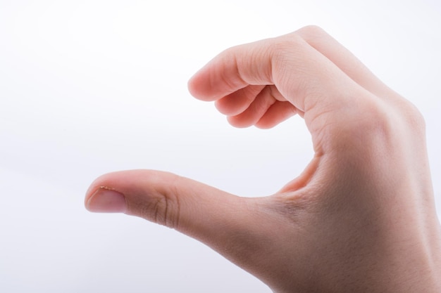 A hand with a thumb in the middle is holding a small object.