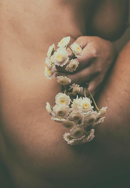 Photo hand with white flowers between female body ii