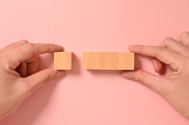 写真 木製のキューブで手を抽象的な背景にモックアップ コピースペース テキストやシンボルのコピースペアの木製のブロック コピー空間の背景