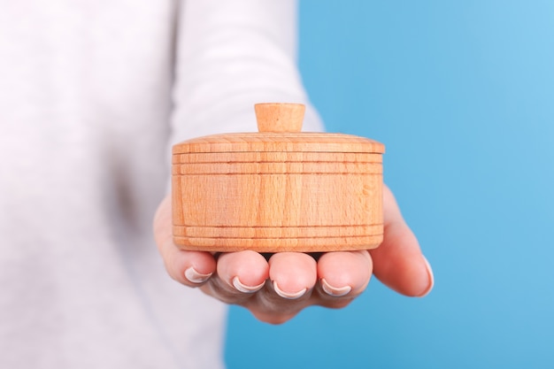 Hand with wooden jar container for salt isolated