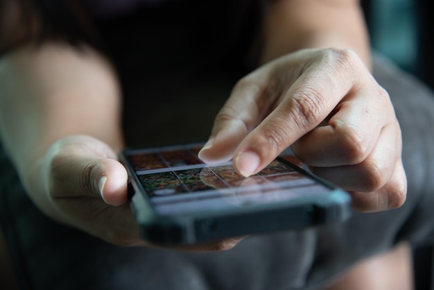 スマートフォンで写真を選ぶ手の女性