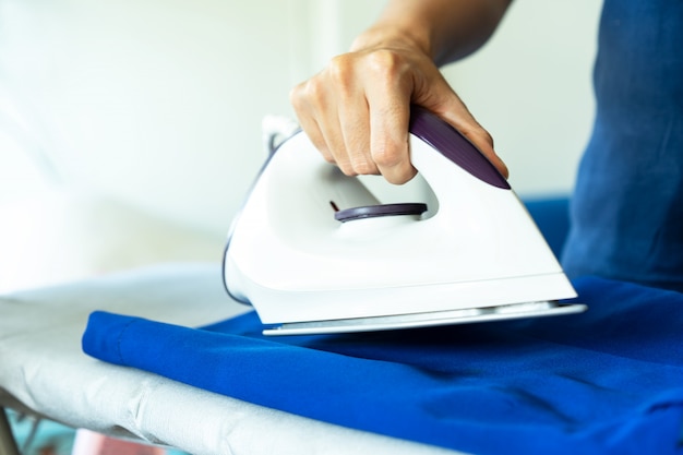 Hand of a woman is ironing.