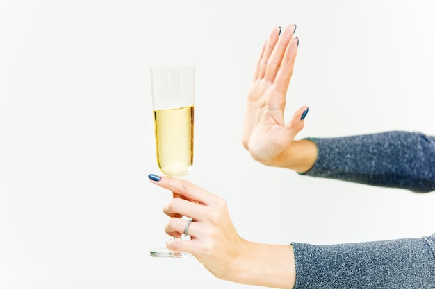 Photo hand of woman refusing glass with alcoholic beverage, on white background. no alcohol concept