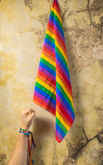 Hand of a woman with closed fist and rainbow bracelet