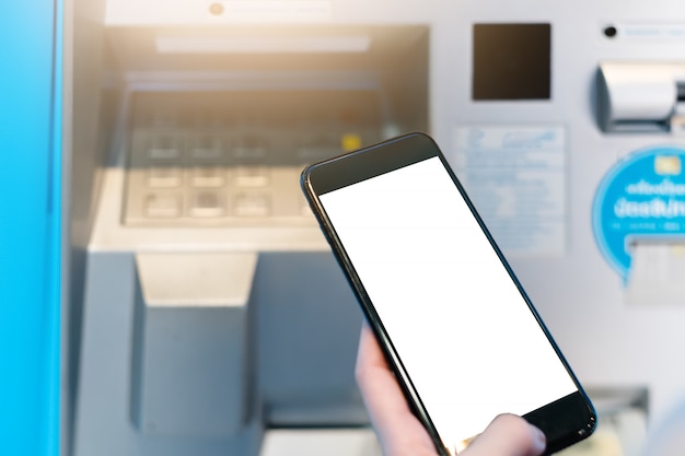 Photo hand of a woman with a credit card, using an atm