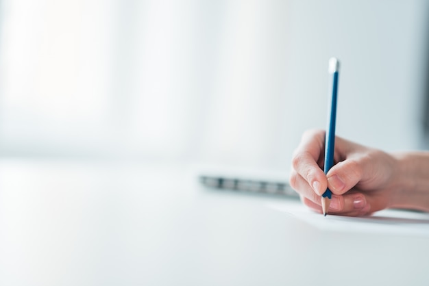 Hand of a woman writing on paper.