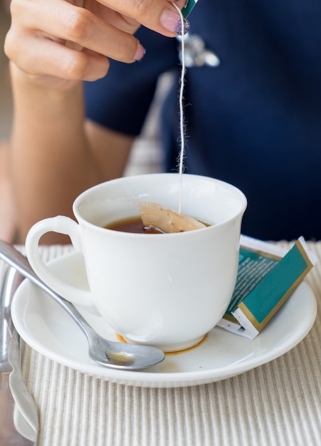 Hand women dipped in tea cup