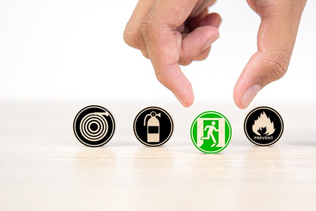 Hand and wooden toy stack with fire prevention icons for safety