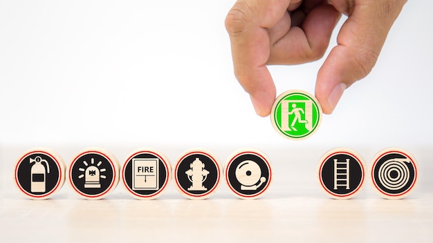 Hand and wooden toy stack with fire prevention icons for safety