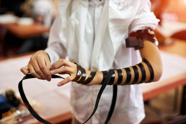 Avvolgere a mano tefilin intorno all'altra mano adolescente ebreo anni celebra bar mitzvah alta qualità...