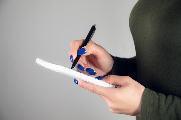 Foto la mano scrive con una penna in un taccuino