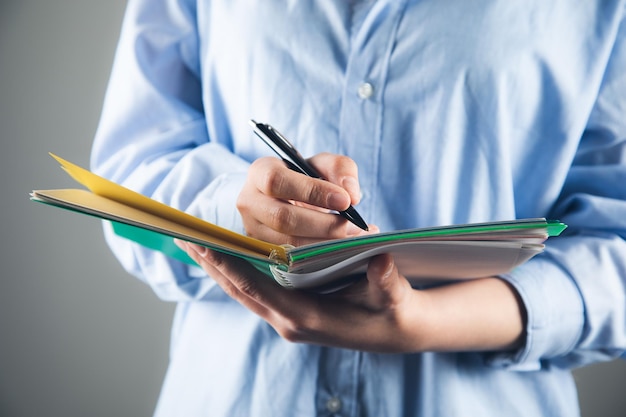 Hand writes with a pen in a notebook