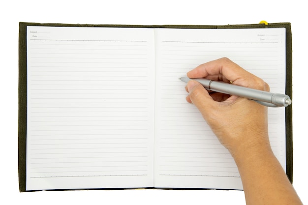 Hand writing in a notebook with pencil on wood table.