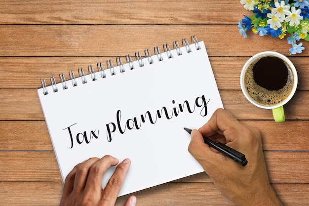 Photo hand writing tax planning word on notebooks