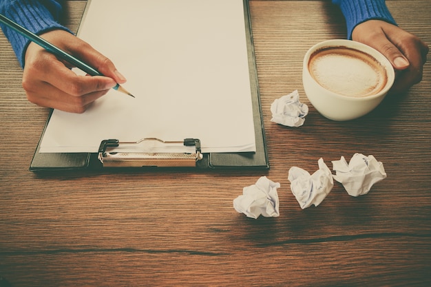 Photo hand writing with cup of coffee